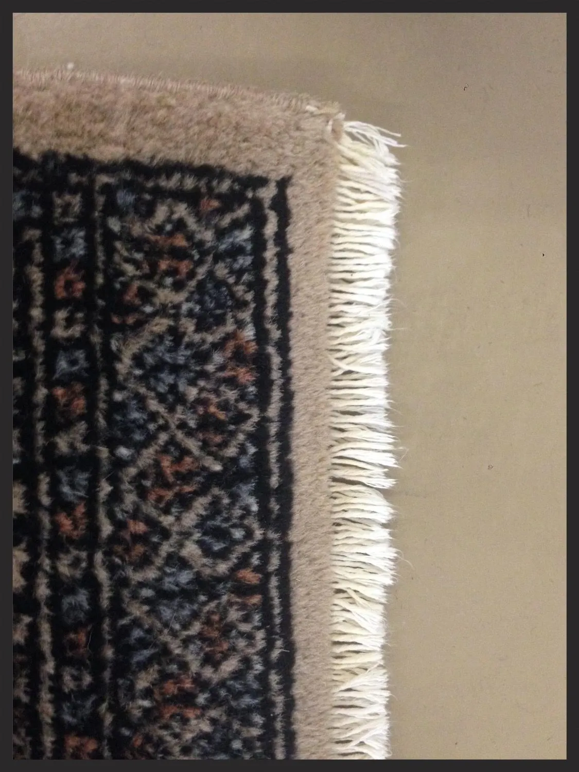 A worn, frayed rug end read for damage before any repair begins